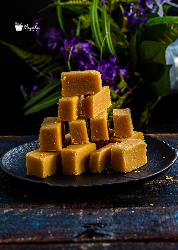 Rich authentic golden Ghee Mysore Pak fudge cubes stacked on an artisanal platter.